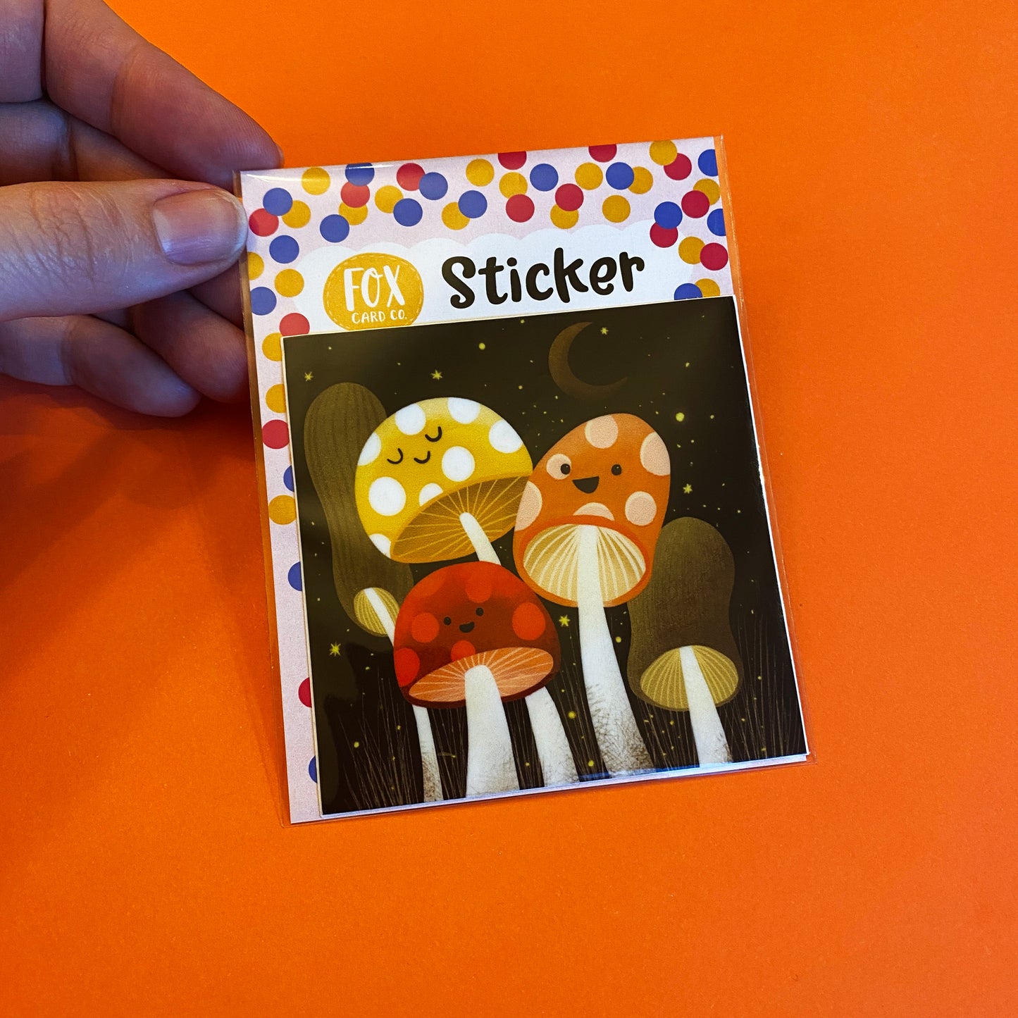 Vinyl sticker featuring an adorable group of happy mushrooms! Original art by Anna Fox Sticker printed with a matte finish on premium vinyl with a strong adhesive. Waterproof, Dishwasher safe and scratchproof sticker that is made to last! 3 inches x 3 inches square sticker. Wrapped in a protective plastic sleeve that is made of plant- based polylactic acid (PLA) and is certified compostable