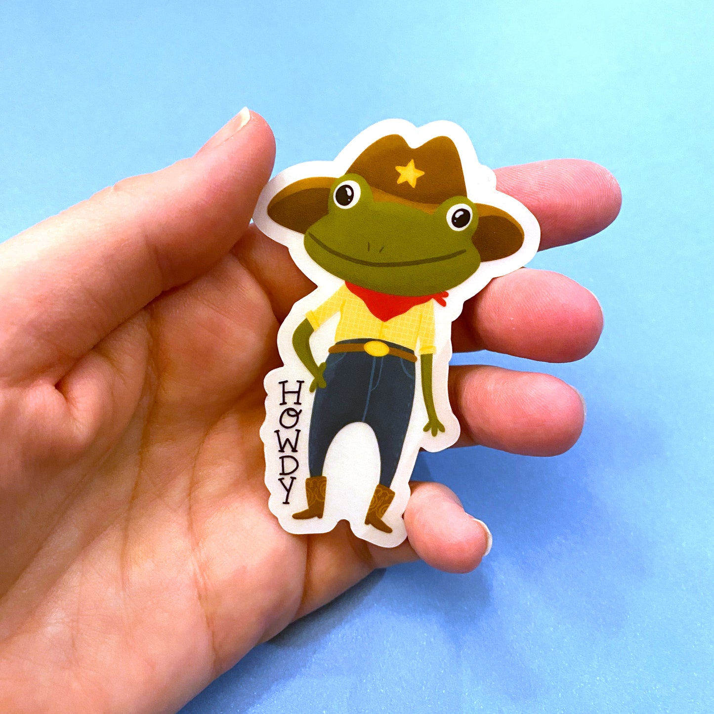 Transparent vinyl sticker featuring an adorable cowboy frog. HOWDY! Oringial design by Anna Fox. Waterproof, Dishwasher safe and scratchproof sticker that is made to last!