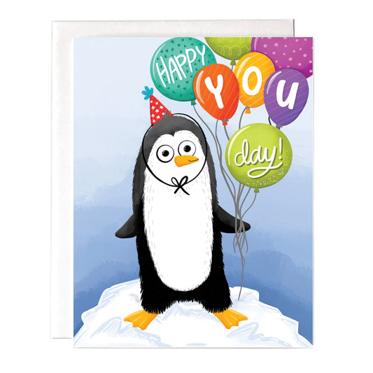 A penguin birthday greeting card with the message “happy you day” on colorful balloons. Size a2 greeting card, blank inside with white envelope.