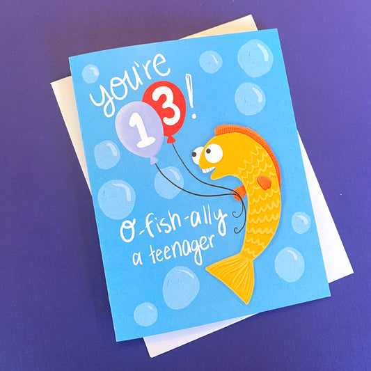 a 13th birthday card with a cute fish on it. The card reads "you're 13, O-FISH-ally a teenager"